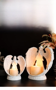 Detailed view of white angel wing candle holders with intricate feather textures