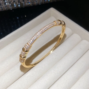 Macro detail of gold plated bracelet with sparkling cubic zirconia on velvet stand