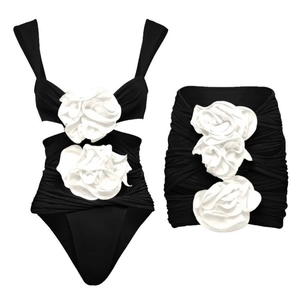 Elegant two-piece swimwear with 3D white flower accents and a pleated wrap skirt
