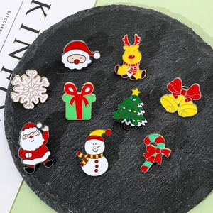 Set of 9 Christmas enamel pins featuring Santa, reindeer and snowman on a black stone plate