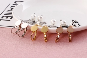 Détail de boucles d'oreilles étoile et perle en finitions or, argent, rose et noir