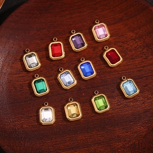 Macro shot of 12-color rectangular gemstone pendants with gold frames on dark wood