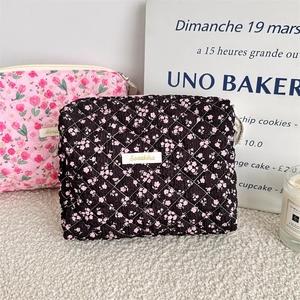 Detail of quilted floral cotton makeup bag with zipper closure and diamond texture