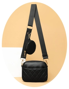 Detail of black quilted crossbody bag with wide strap and matching round coin purse