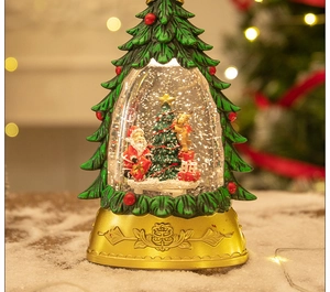 Detailed view of a green Christmas tree snow globe with Santa and golden base
