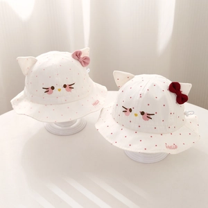 Detailed view of baby sun hats featuring pink and red bows with embroidered cat ears
