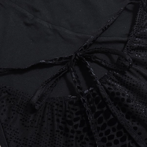 Macro shot of black hollow texture fabric and cross-strap lace-up detail of the dress
