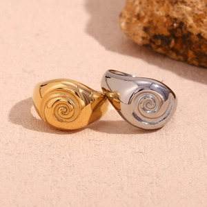 Polished stainless steel spiral swirl rings in gold and silver finish on stone base