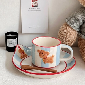 Detail of hand-painted ceramic puppy mug set with striped tray and wooden spoon
