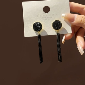 Detail view of elegant black fringe earrings with silver posts and sparkling tassel design