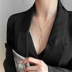Minimalist V-shaped gold pendant necklace on a model with titanium steel chain