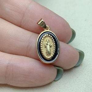 Golden Virgin Mary oval pendant with black enamel trim and sunburst relief design