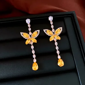Elegant drop earrings featuring yellow zircon butterfly and pear-shaped crystals in silver