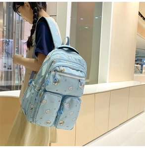 Side view of large light blue backpack with cute bear pattern on a student model