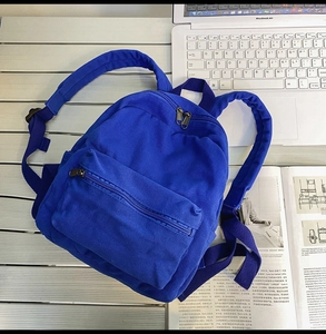 Detail der Textur des dunkelblauen Canvas-Rucksacks auf dem Schreibtisch mit Laptop