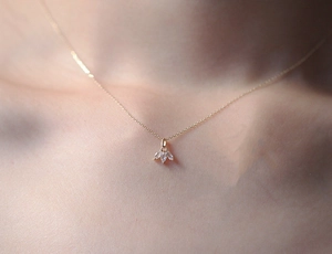 Close-up of gold S925 sterling silver necklace with three marquise-cut diamond leaves