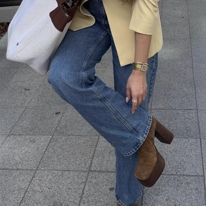 Elegant women's round neck blazer jacket paired with blue jeans and brown platform boots