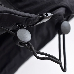 Close-up of black adjustable drawstring and elastic toggle on nylon puffer vest fabric