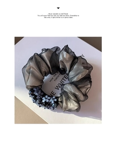Detail of dark grey mesh scrunchie featuring elegant bead flower cluster and soft pleats