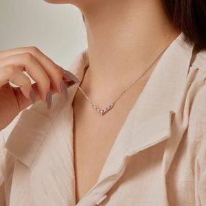 Close-up of S925 sterling silver necklace with colorful zircon heart on a female neck
