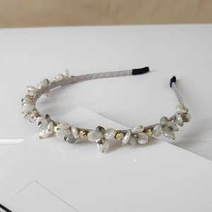 Detailed view of handcrafted light gray headband with crystals and faux pearls