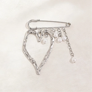 Detail of silver liquid lava heart pendant brooch with pearls and delicate chain