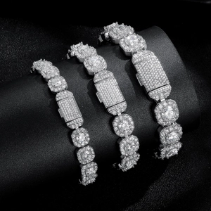 Close-up of three silver hip-hop Cuban link bracelets with cubic zirconia on black stand