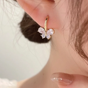 Elegant gold butterfly earrings with sparkling cubic zirconia crystals worn by a woman