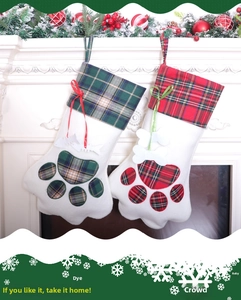 Detail of red and green plaid cat paw Christmas stockings hanging on a white fireplace