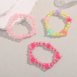 Detailed view of colorful star-shaped acrylic beaded bracelets on a textured background