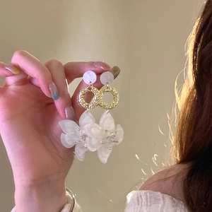 Detailed shot of resin flower earrings with marble studs and golden texture rings