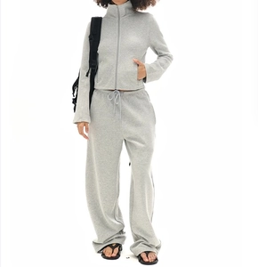 Macro detail of the gray zip-up sweatshirt jacket and matching wide-leg drawstring pants