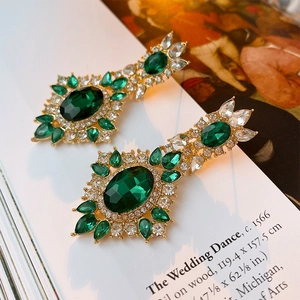 Macro detail of emerald oval drop earrings with vintage crystal inlay and gold finish