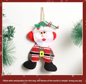 Detail of plush Santa Claus ornament with knitted red hat and green holly leaf accents