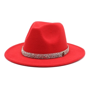 Detail of red wide-brimmed wool fedora with sparkling rhinestones and an M metal badge