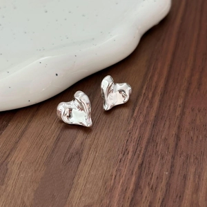 925 sterling silver heart stud earrings with liquid metal texture on ceramic plate