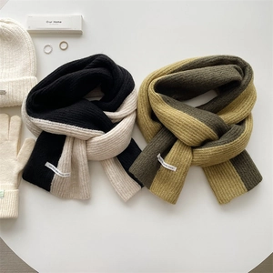 Thick color-block knit scarf for women with matching winter hat and gloves on white table