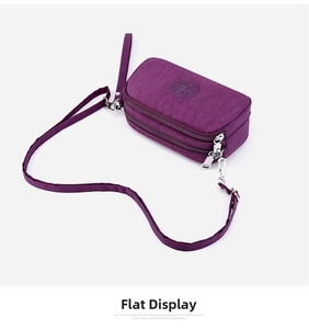 Detail view of deep purple nylon crossbody bag with multi-layer zippers and logo