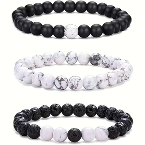 Close-up of beaded bracelet set with lava stone, white turquoise, and matte black beads