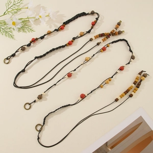Detail of bohemian hand-woven waist ropes with colorful beads and bronze metal rings