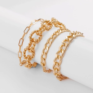 Set of four assorted gold metal chain bracelets including paperclip and chunky link styles