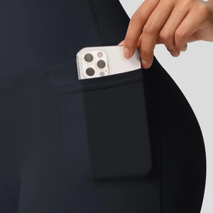Detail of high-waist yoga shorts featuring a functional side pocket for smartphones