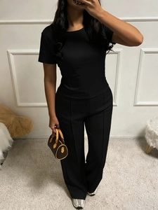 Mirror selfie showing the fit of a black short sleeve T-shirt and casual trousers set