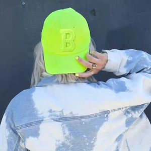 Neon green baseball cap with towel-embroidered letter B on stylish denim jacket model