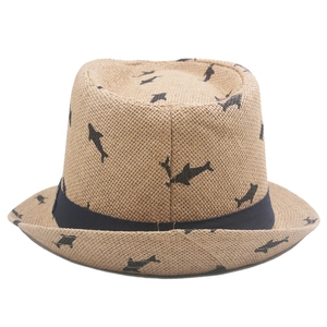 Detail of khaki straw fedora featuring black shark patterns and navy blue decorative band