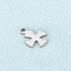 Macro shot of polished silver cross pendant with top loop on blue textured background