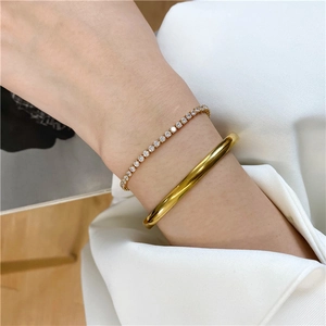 Minimalist 18K gold plated bangle and tennis bracelet set styled on a female wrist