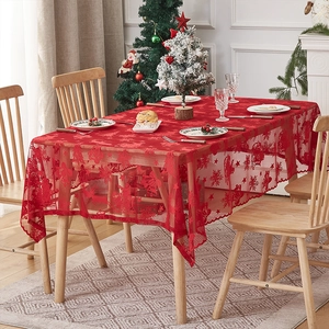 Nappe de Noël rouge en dentelle avec motifs rennes et flocons sur une table à manger
