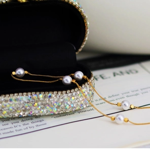 Detailed shot of a French pearl choker necklace draped over a luxury rhinestone jewelry box