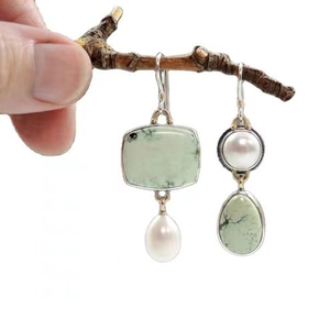 Asymmetric light green enamel earrings with pearls and silver hooks on white background